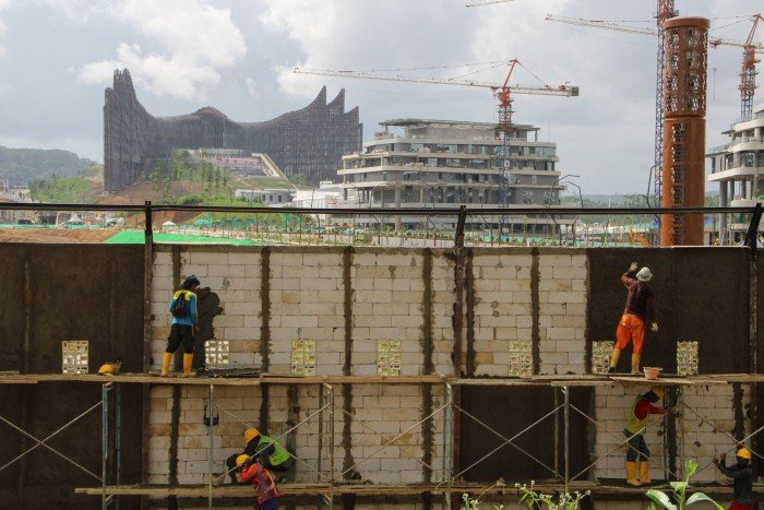 Cranes can be seen in the background, along with a futuristic building taking shape.